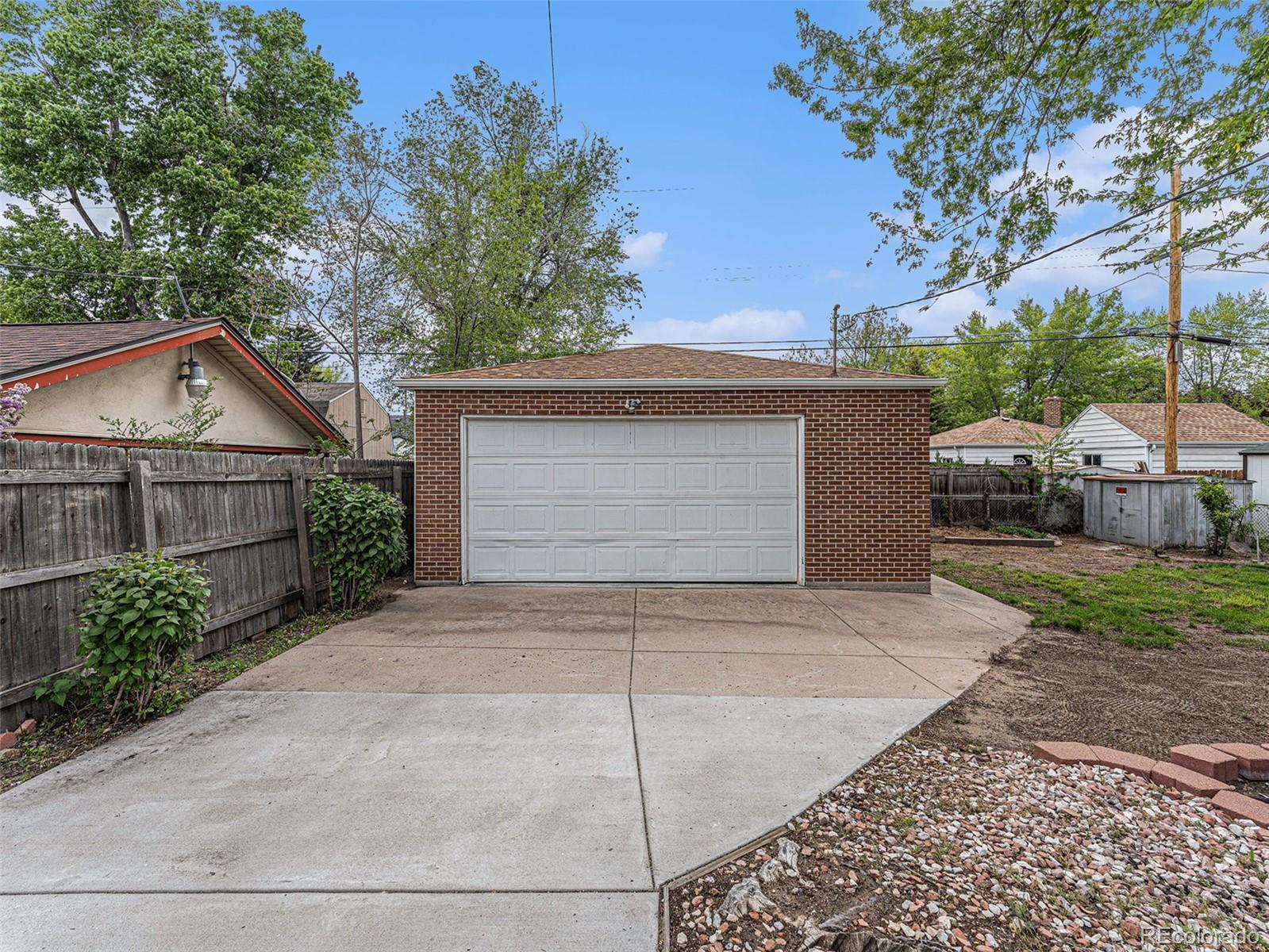 3895 Pierce Street Wheat Ridge, CO 80033 - Photo 26 of 33 a front view of a house with a yard and garage