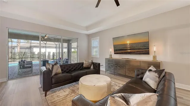 a living room with furniture a ceiling fan a fireplace and a large window
