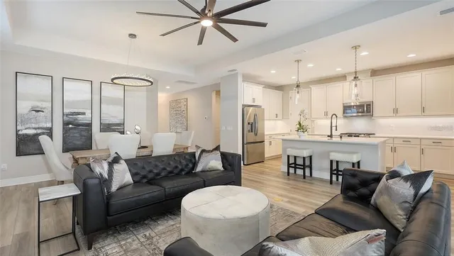 a kitchen with stainless steel appliances granite countertop a sink a stove a refrigerator and island with wooden floor