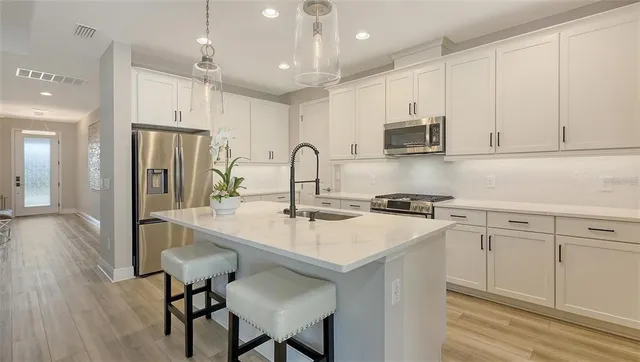 a kitchen with a stove a sink a dining table and chairs