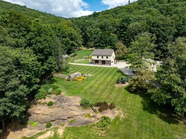 a backyard of a house with a yard and outdoor seating