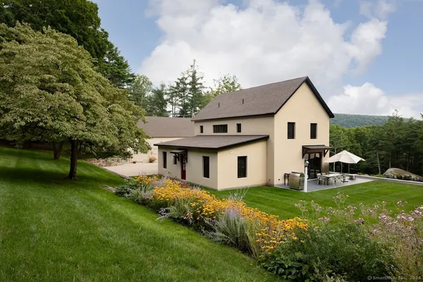 a aerial view of a house next to a big yard and large trees