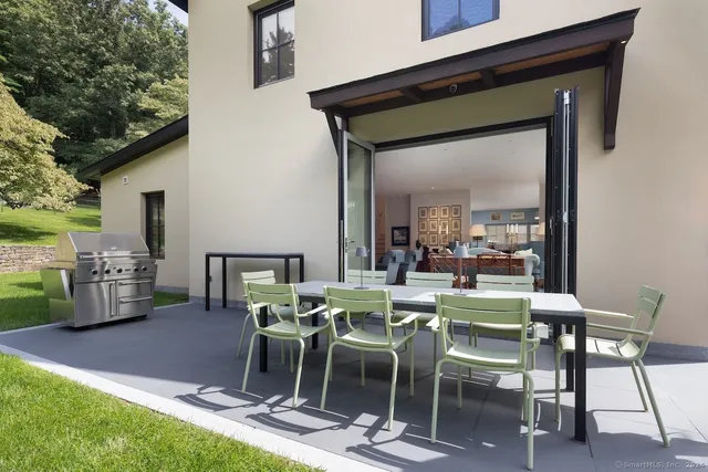 a view of an outside dining space with a table and chairs