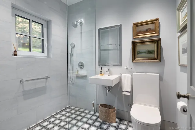 a bathroom with a sink a toilet and shower