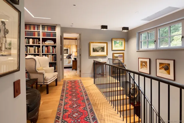 a living room with furniture wooden floor and a book shelf