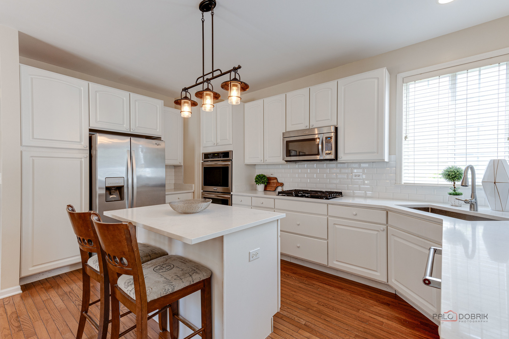 1628 Canfield Road Park Ridge, IL 60068 - Photo 8 of 29 a kitchen with stainless steel appliances a stove a sink a refrigerator a microwave a dining table and chairs