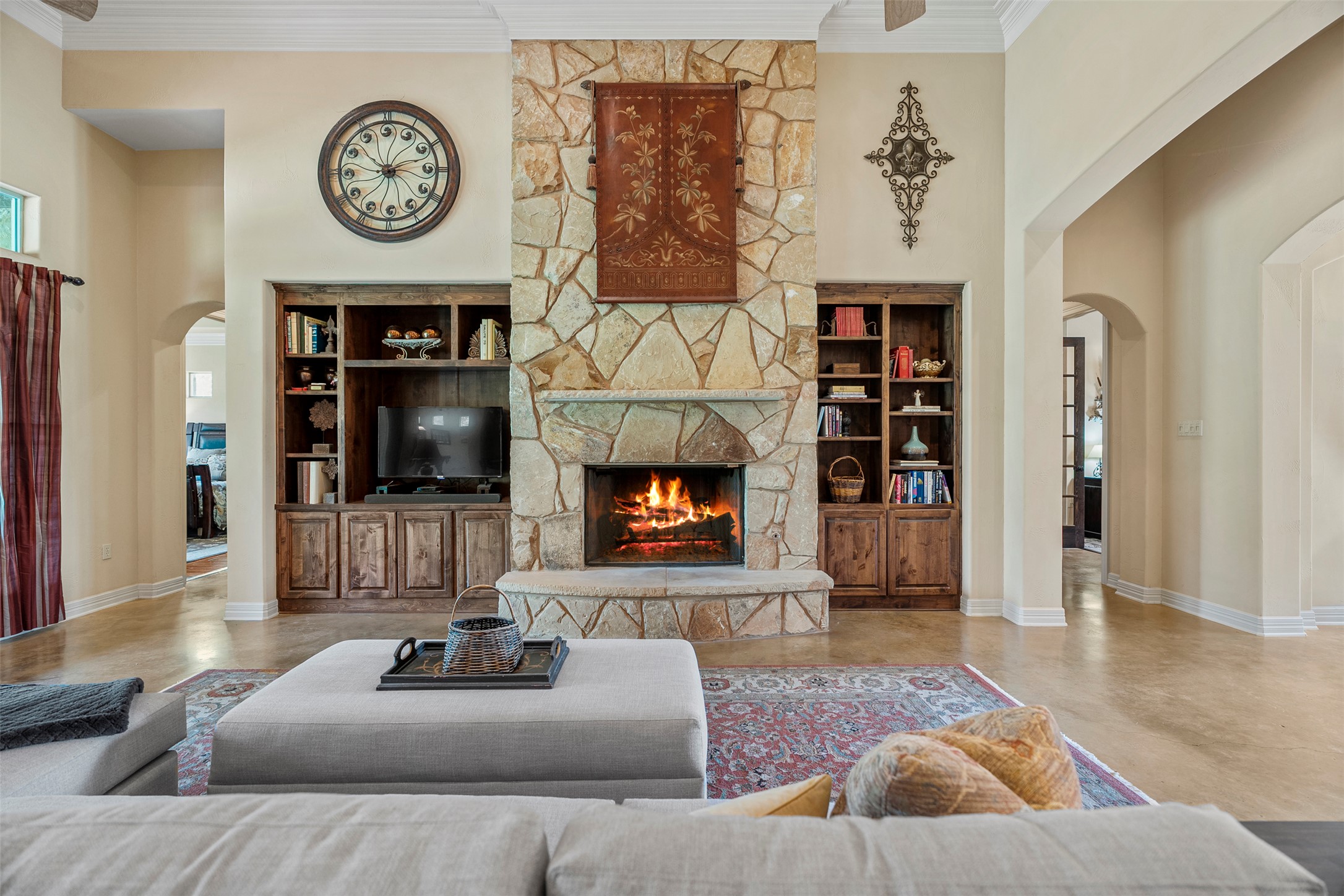100 Portafino Lane Georgetown, TX 78633 - Photo 3 of 39 Living area with arched walkways, a fireplace, crown molding, built in features, and a towering ceiling