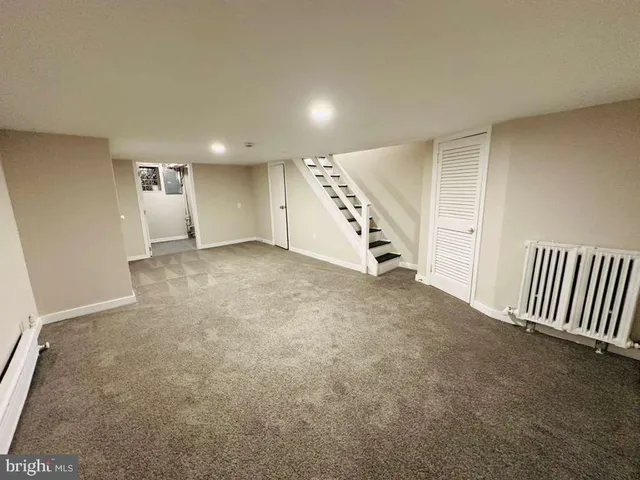 an empty room with windows and stairs
