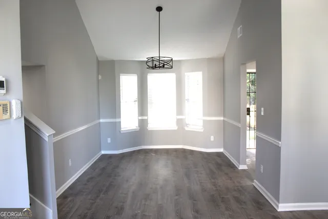 a view of a room with wooden floor and windows