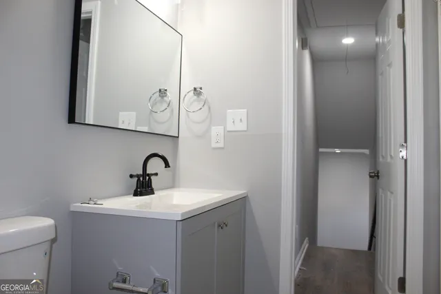 a bathroom with a sink a toilet and mirror