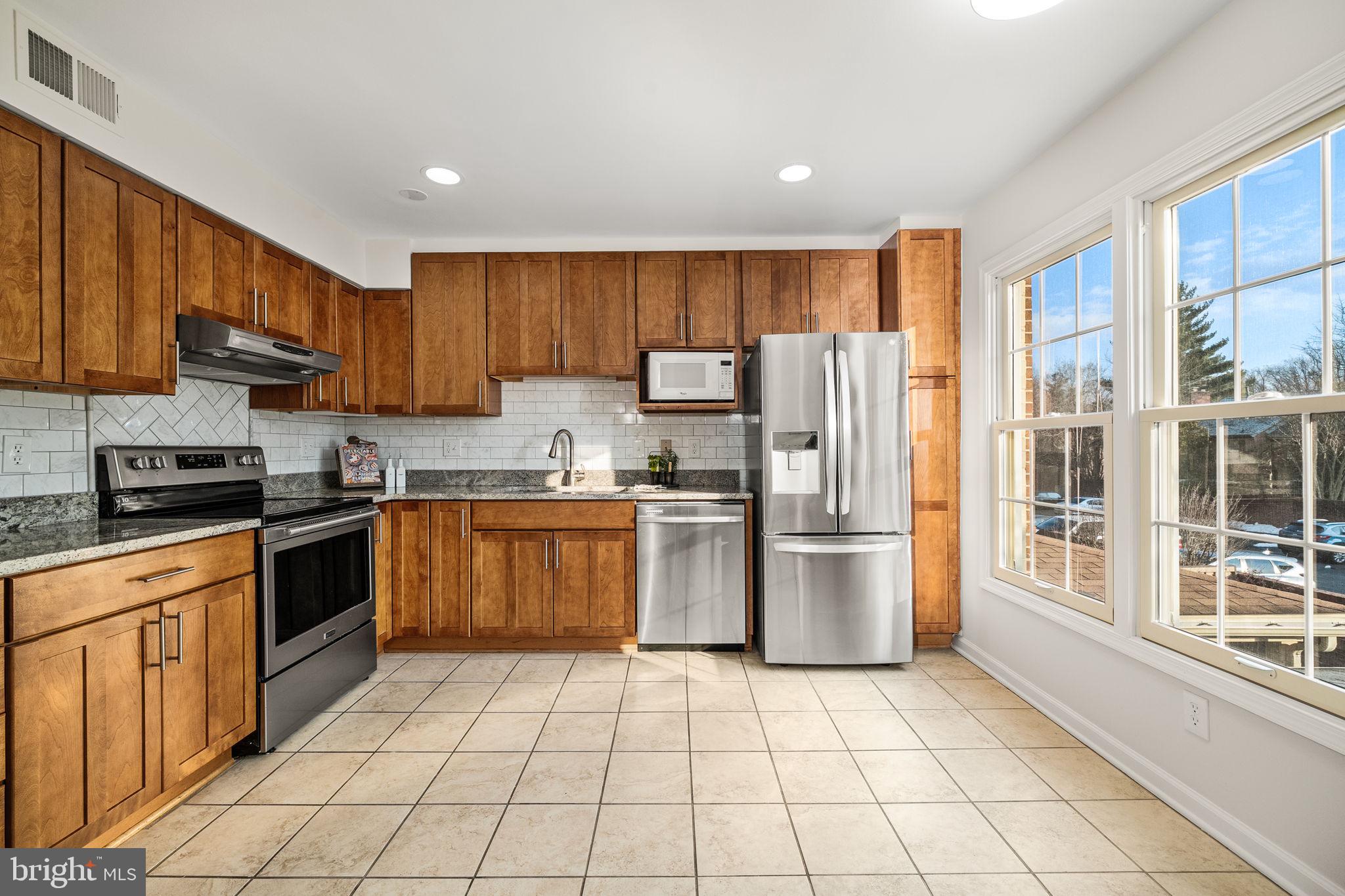 8333 Garfield Court Springfield, VA 22152 - Photo 17 of 60 a kitchen with a refrigerator a stove top oven a sink and cabinets