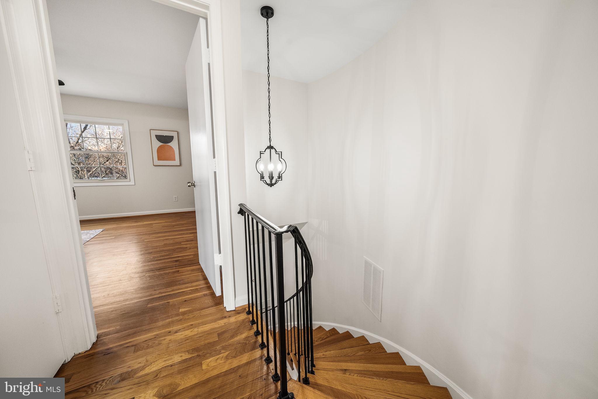 8333 Garfield Court Springfield, VA 22152 - Photo 25 of 60 a view of a hallway with wooden floor and staircase