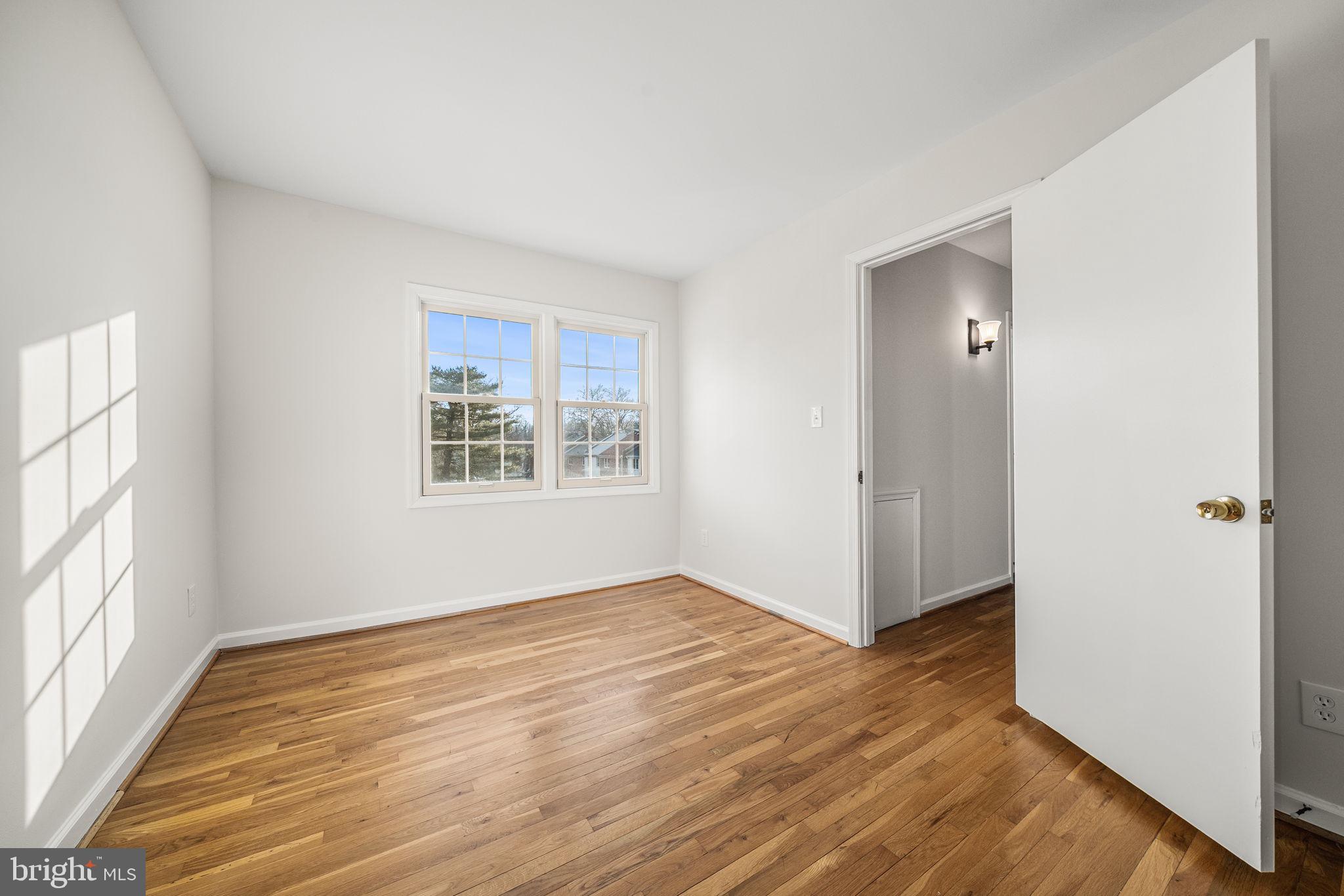 8333 Garfield Court Springfield, VA 22152 - Photo 36 of 60 an empty room with wooden floor cabinet and windows