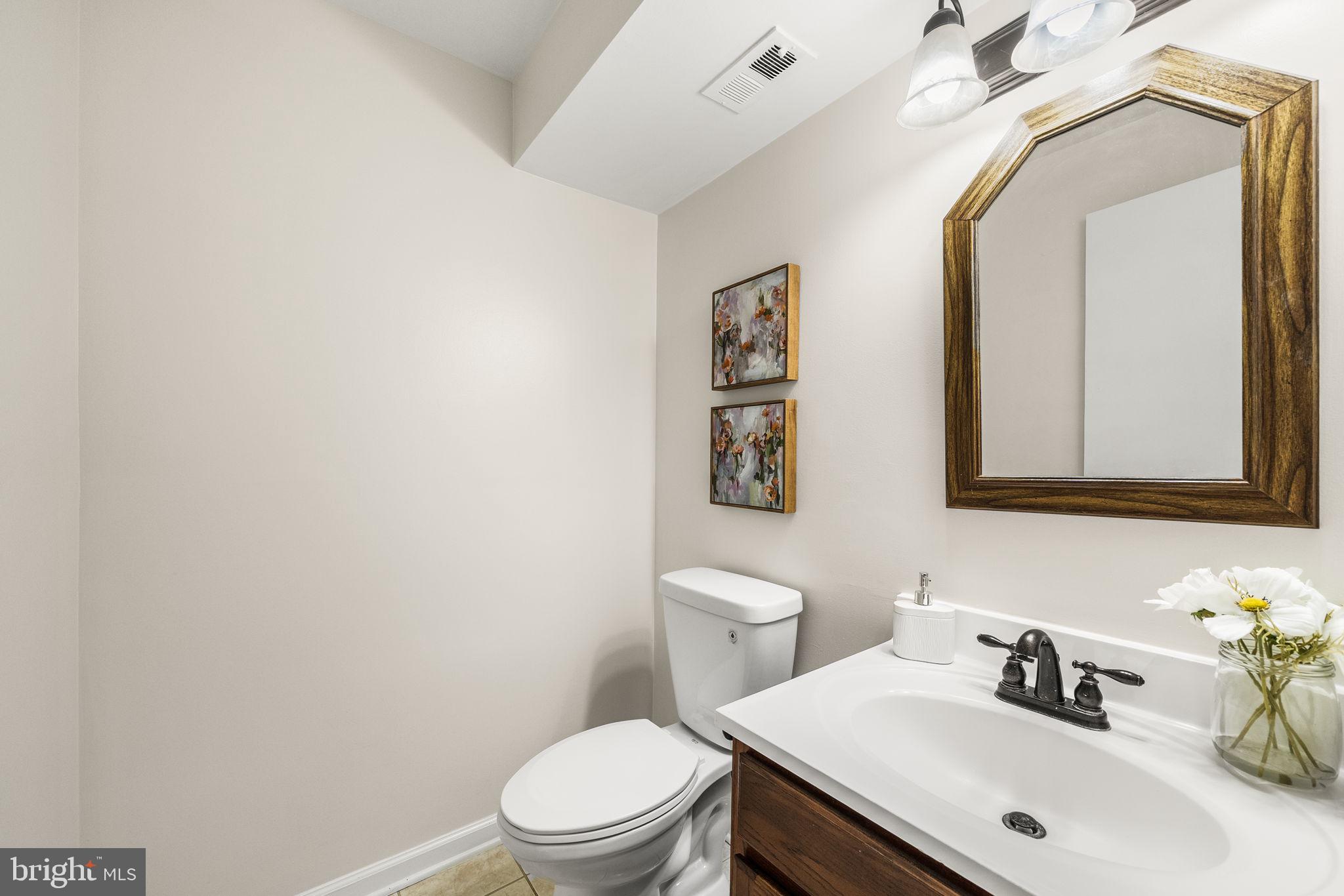 8333 Garfield Court Springfield, VA 22152 - Photo 49 of 60 a bathroom with a toilet sink vanity and mirror