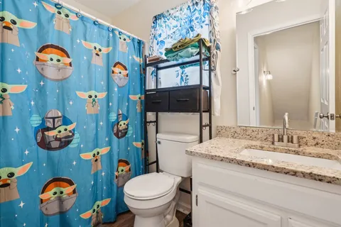 a bathroom with a sink mirror and toilet