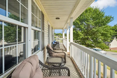 a balcony view with a large window and furniture