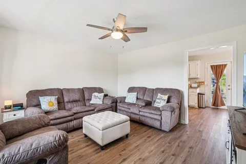 a living room with furniture and a wooden floor