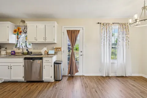 a kitchen with stainless steel appliances granite countertop a refrigerator sink and white cabinets