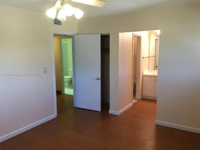 an empty room with windows and closet