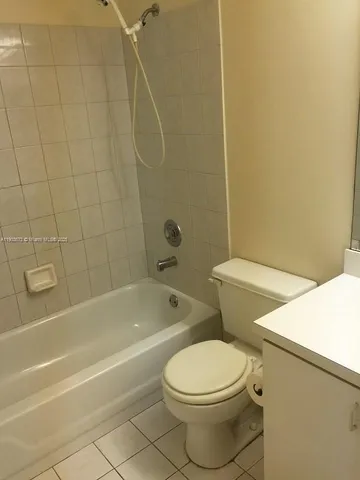 a white toilet and tub sitting next to a bathroom sink