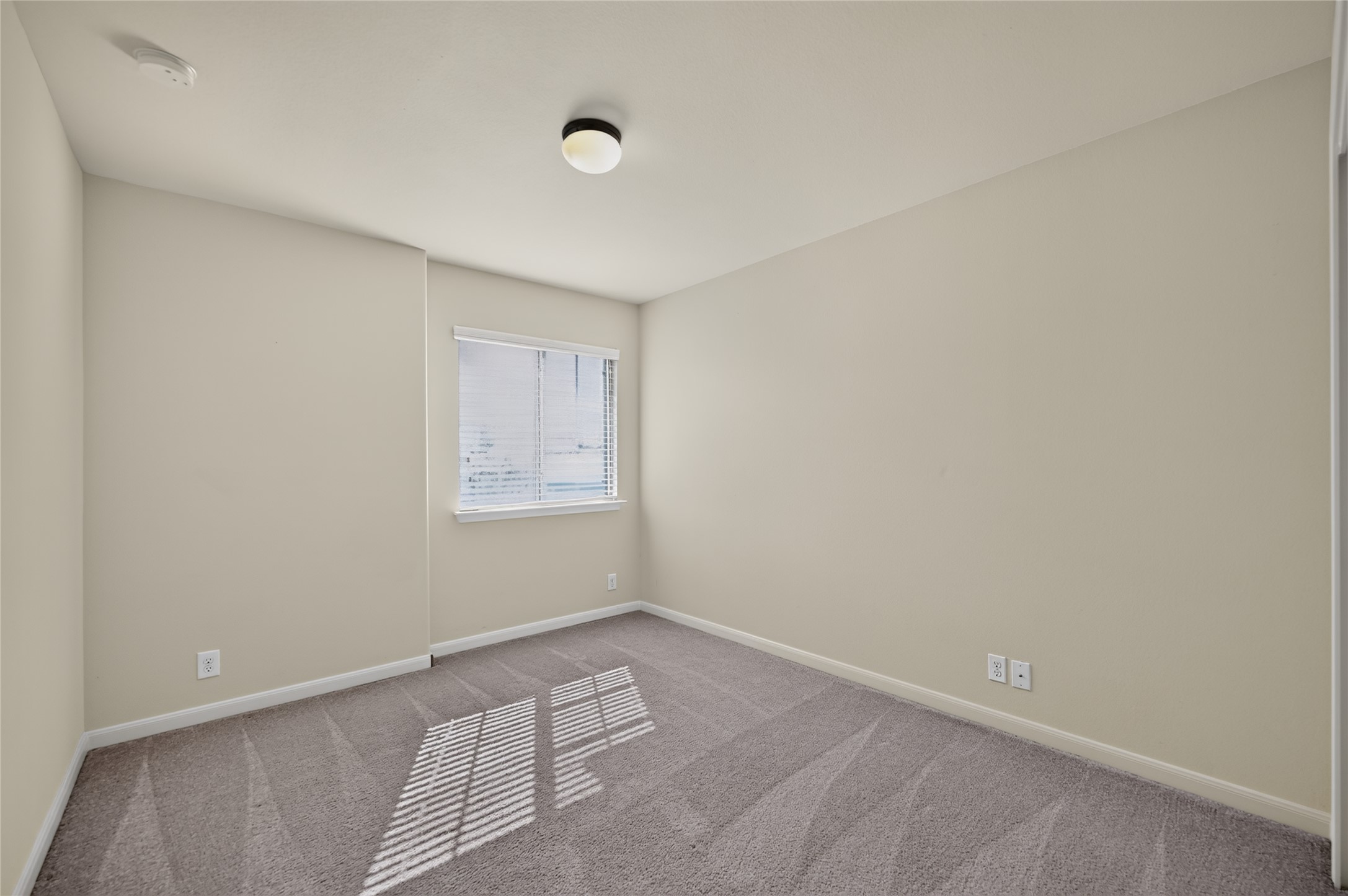 504 Old Peak Road Georgetown, TX 78626 - Photo 22 of 25 A well-lit bedroom features plush carpet flooring and a single window, offering a neutral canvas.