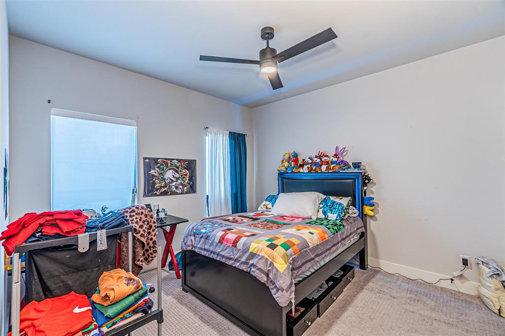 1503 Morrell Avenue Dallas, TX 75203 - Photo 24 of 30 a bedroom with a bed a dresser and a chandelier