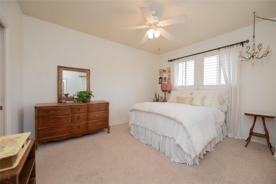 5402 Beacon Drive, Unit A Austin, TX 78734 - Photo 32 of 40 a bedroom with a bed chandelier and a window