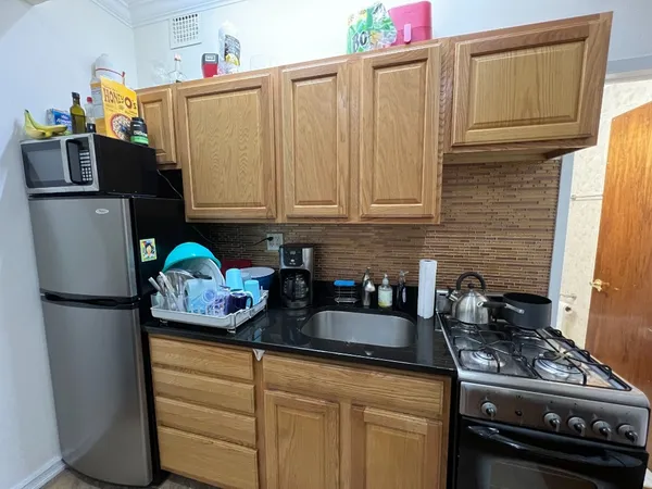 a kitchen with stainless steel appliances granite countertop a refrigerator stove and sink