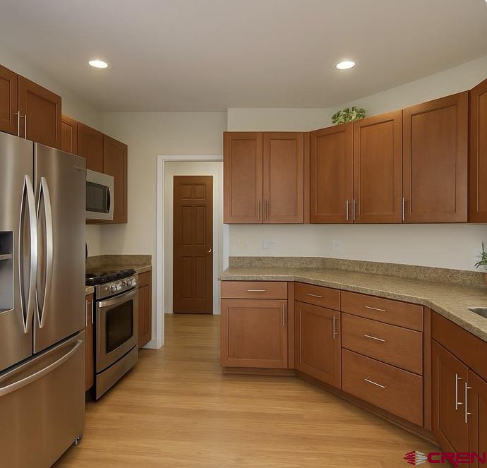1711 Golf Course Lane Cortez, CO 81321 - Photo 18 of 45 a kitchen with granite countertop stainless steel appliances and wooden cabinets