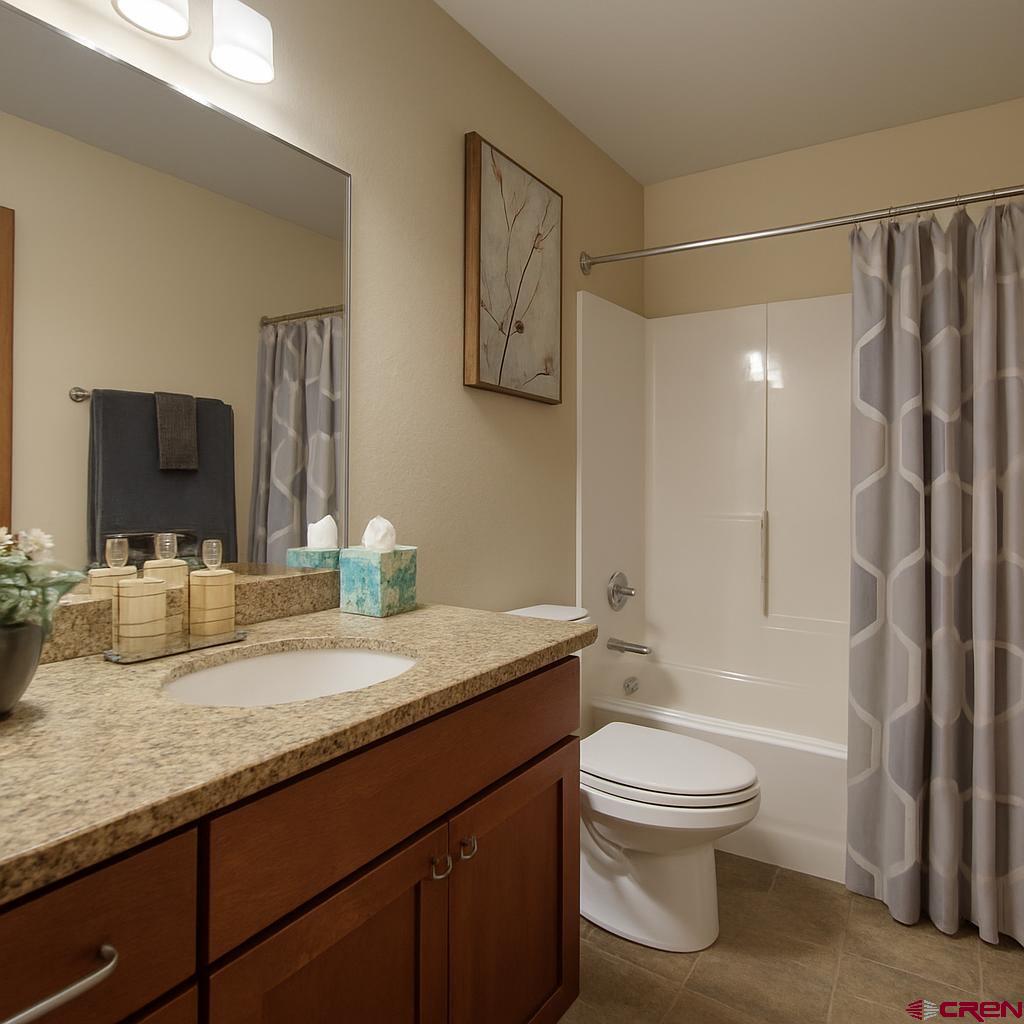 1711 Golf Course Lane Cortez, CO 81321 - Photo 24 of 45 a bathroom with a granite countertop sink a toilet and a large mirror