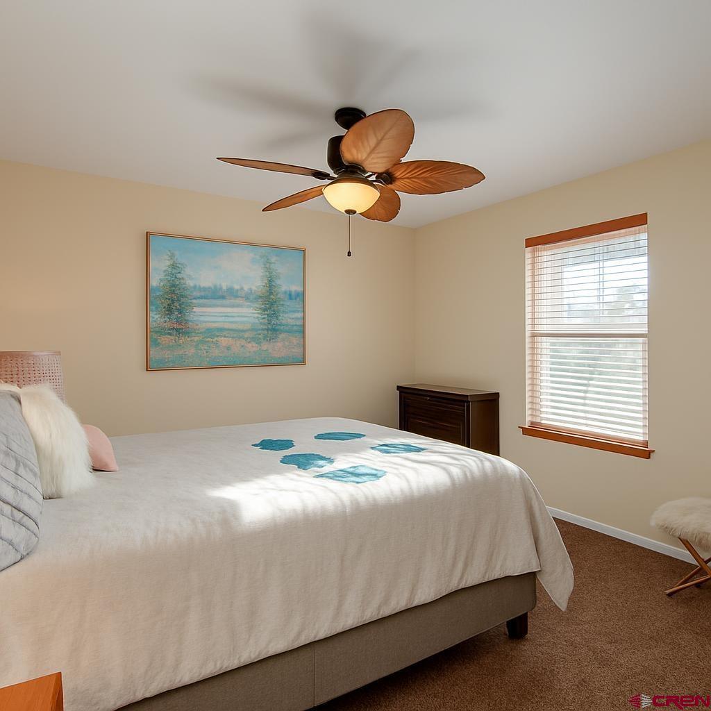 1711 Golf Course Lane Cortez, CO 81321 - Photo 27 of 45 a bedroom with a bed ceiling fan and window
