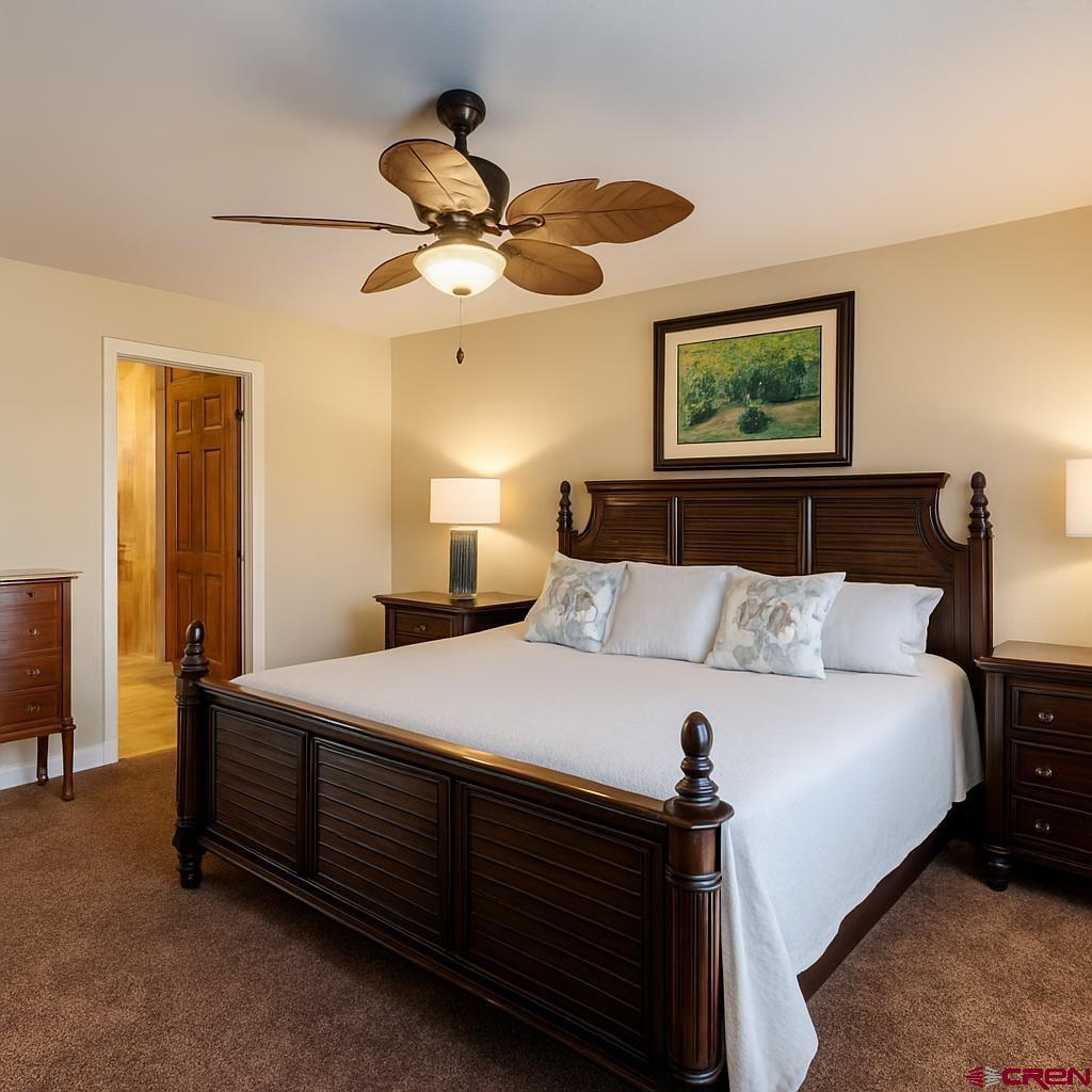 1711 Golf Course Lane Cortez, CO 81321 - Photo 32 of 45 a bedroom with a bed and a chandelier