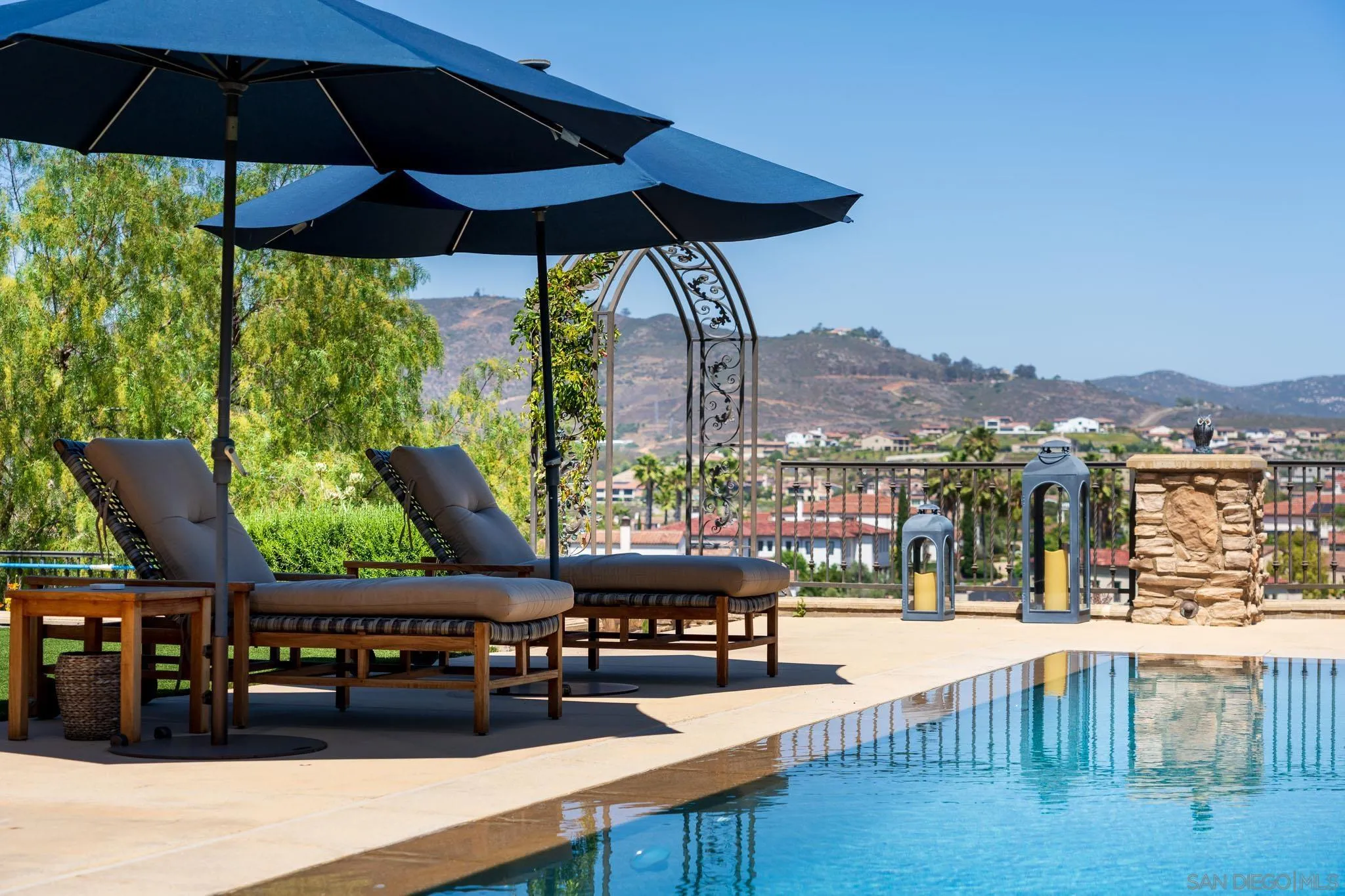 8053 High Time Ridge San Diego, CA 92127 - Photo 52 of 62 a view of a swimming pool with a table and chairs under an umbrella
