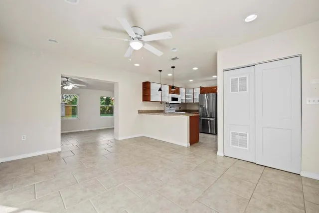 a view of a kitchen with a sink and dishwasher a refrigerator with white cabinets