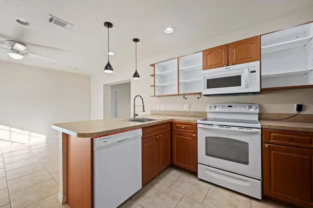 a kitchen with stainless steel appliances granite countertop a kitchen island a stove a sink and a microwave