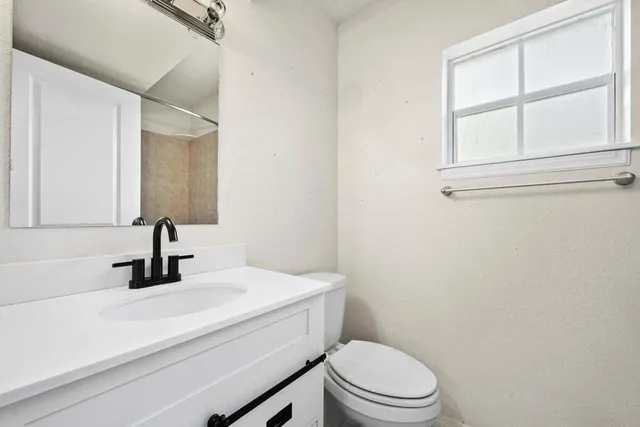 a bathroom with a sink a toilet and mirror