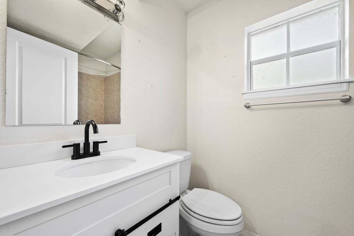 1875 45th Avenue Vero Beach, FL 32966 - Photo 6 of 14 a bathroom with a sink a toilet and mirror