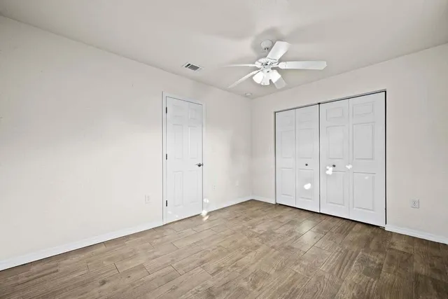 a view of an empty room with wooden floor