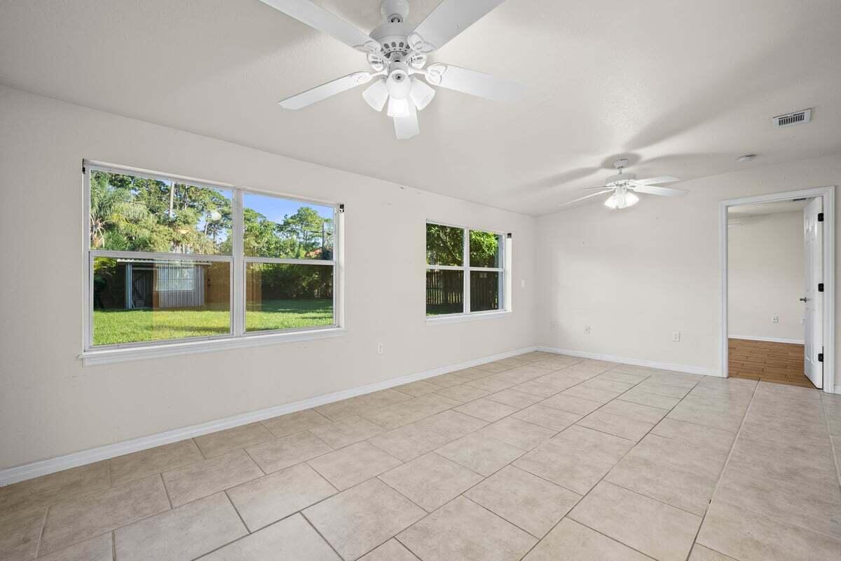 1875 45th Avenue Vero Beach, FL 32966 - Photo 9 of 14 a view of an empty room with a window and a ceiling fan