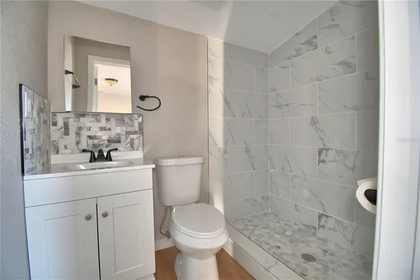 a bathroom with a sink a toilet and shower