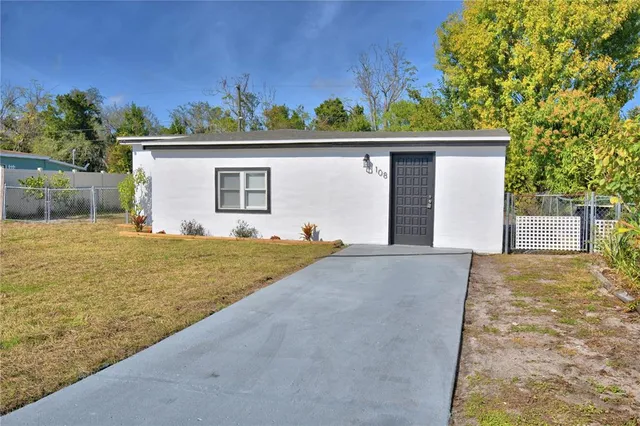 a view of a house with a yard and potted plants