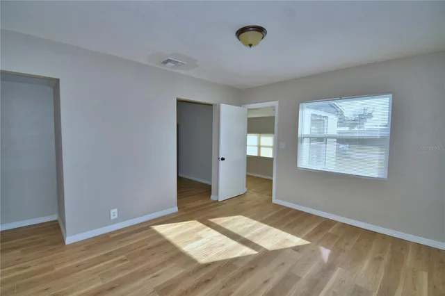 a view of empty room with wooden floor