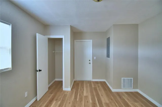 a view of hallway with closet and wooden floor