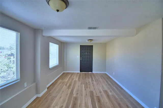 a view of a room with wooden floor and window