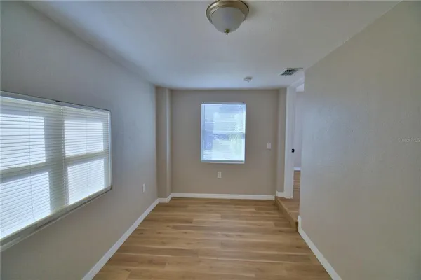 a view of a hallway with wooden floor and closet