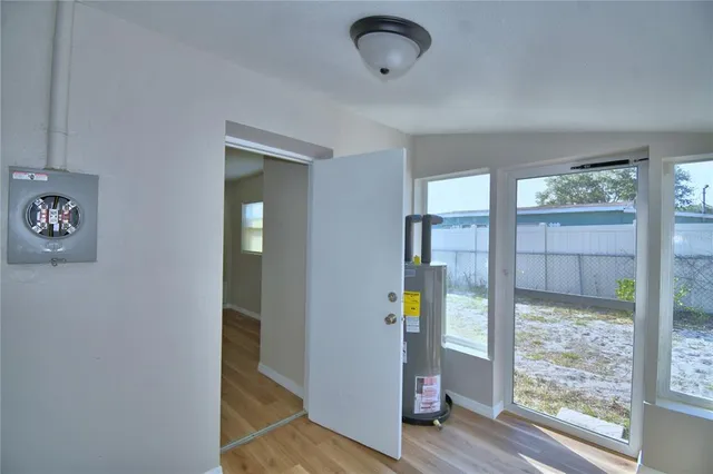 a view of an empty room with wooden floor and windows