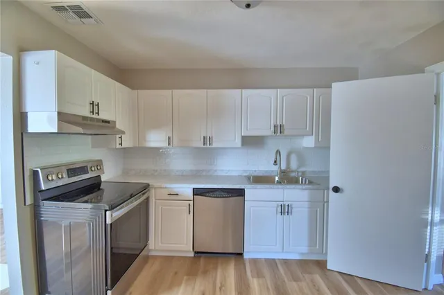 a kitchen with a sink a stove and cabinets