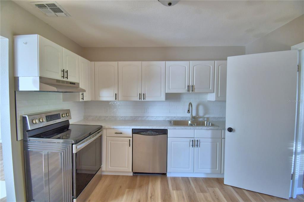 108 Yale Avenue Frostproof, FL 33843 - Photo 4 of 42 a kitchen with a sink a stove and cabinets