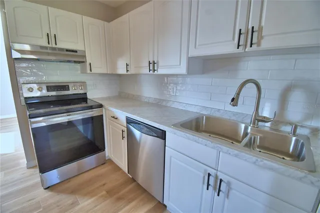 a kitchen with cabinets a sink and stainless steel appliances
