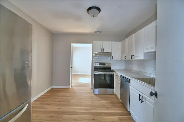 a kitchen with stainless steel appliances granite countertop a stove and a refrigerator